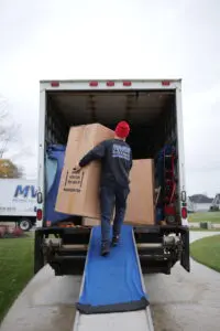MVM Moving & Storage loading boxes into a moving truck from a checklist