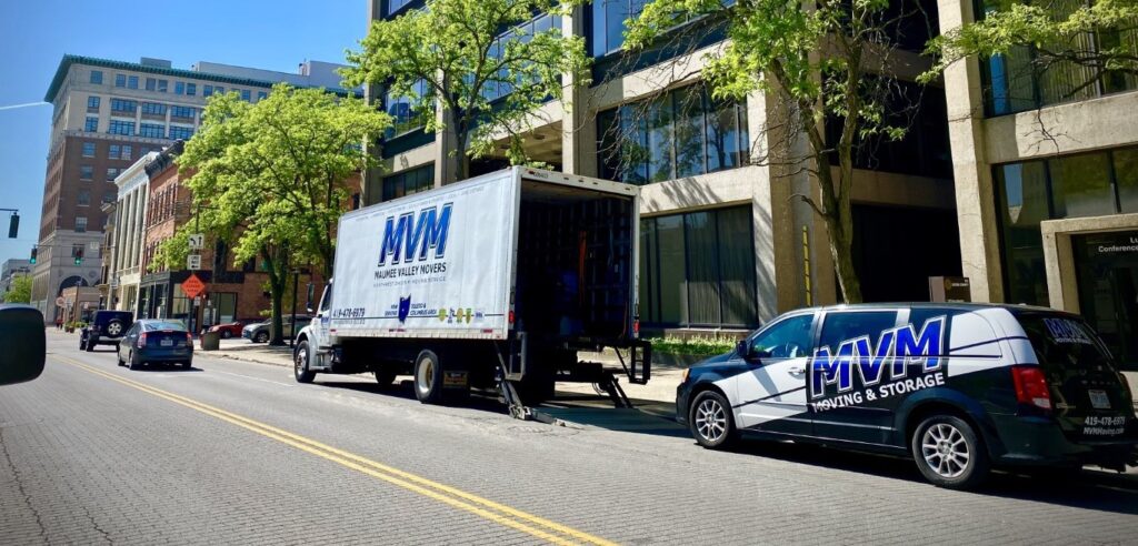 MVM truck and van in city outside building