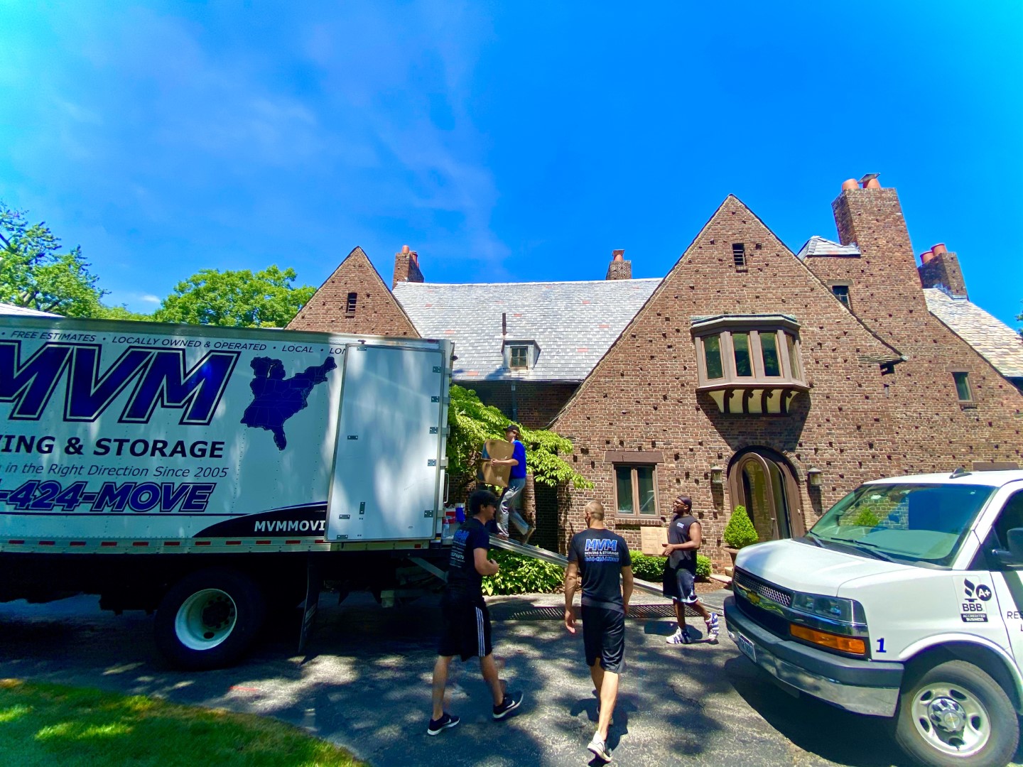 MVM truck and movers outside house loading truck